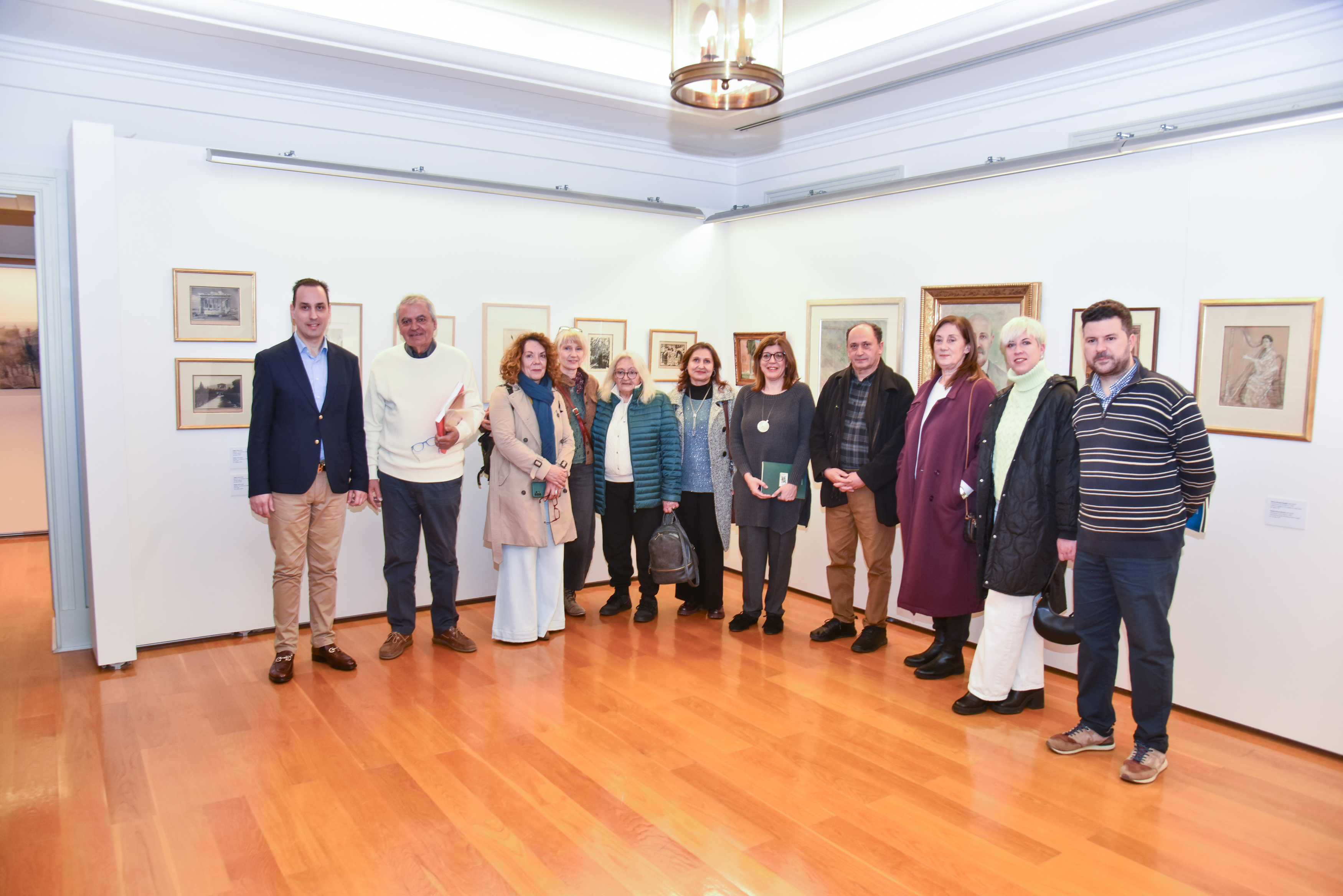 Participants of the tour photographed in front of artworks inside a museum hall. Highlight from the guided tour