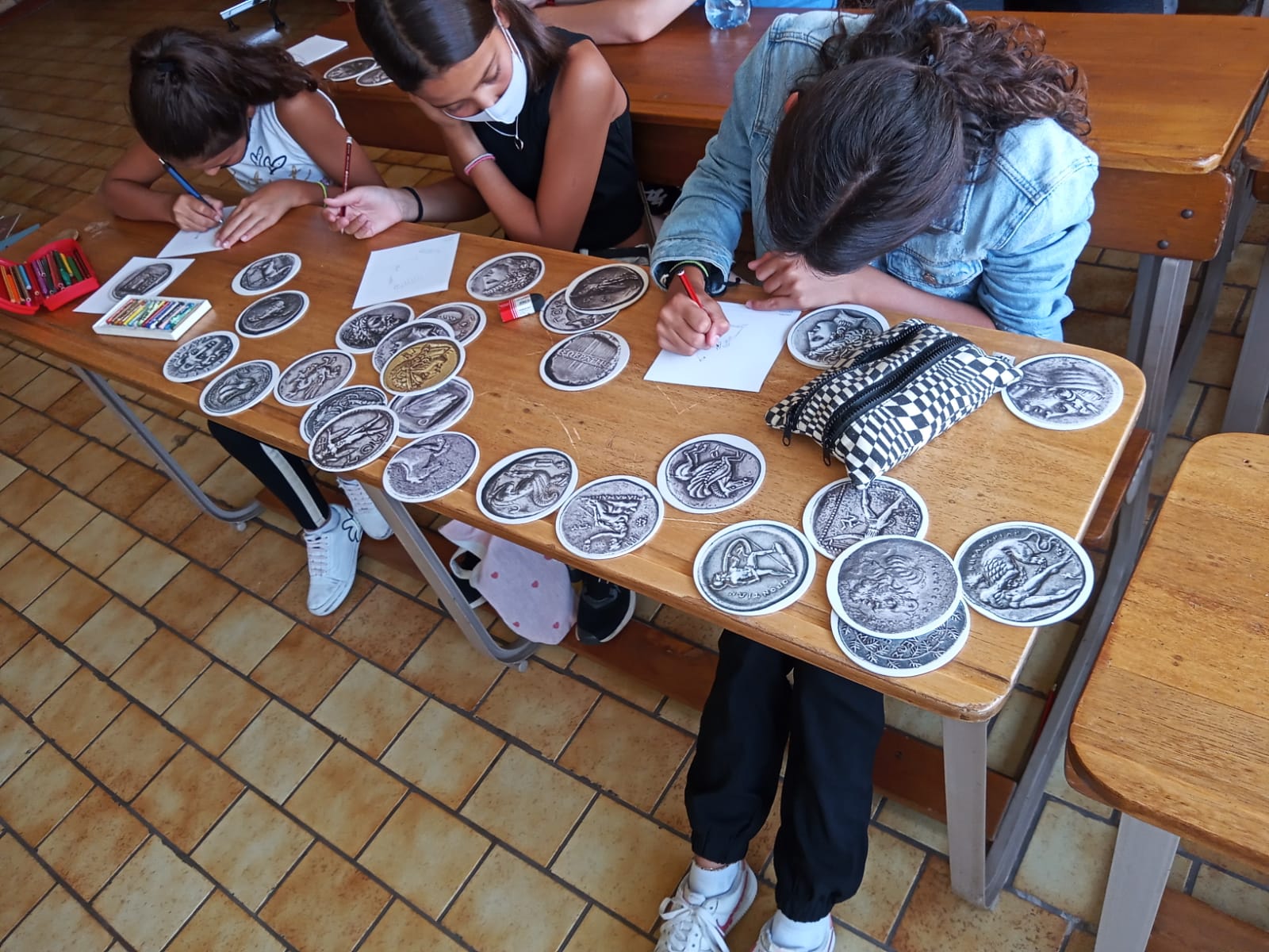 Children painting around a desk with coin replicas.   The Museum Cases in Pretoria at South Africa