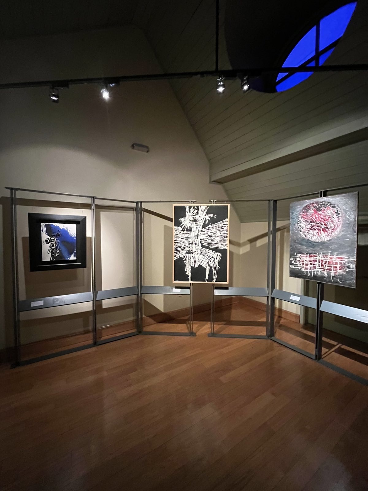 Room with an iron display case and 3 paintings. In the middle the painting Untiltled, acrylic on canvas. The exhibition venue at the Municipal Art Gallery of Thessaloniki