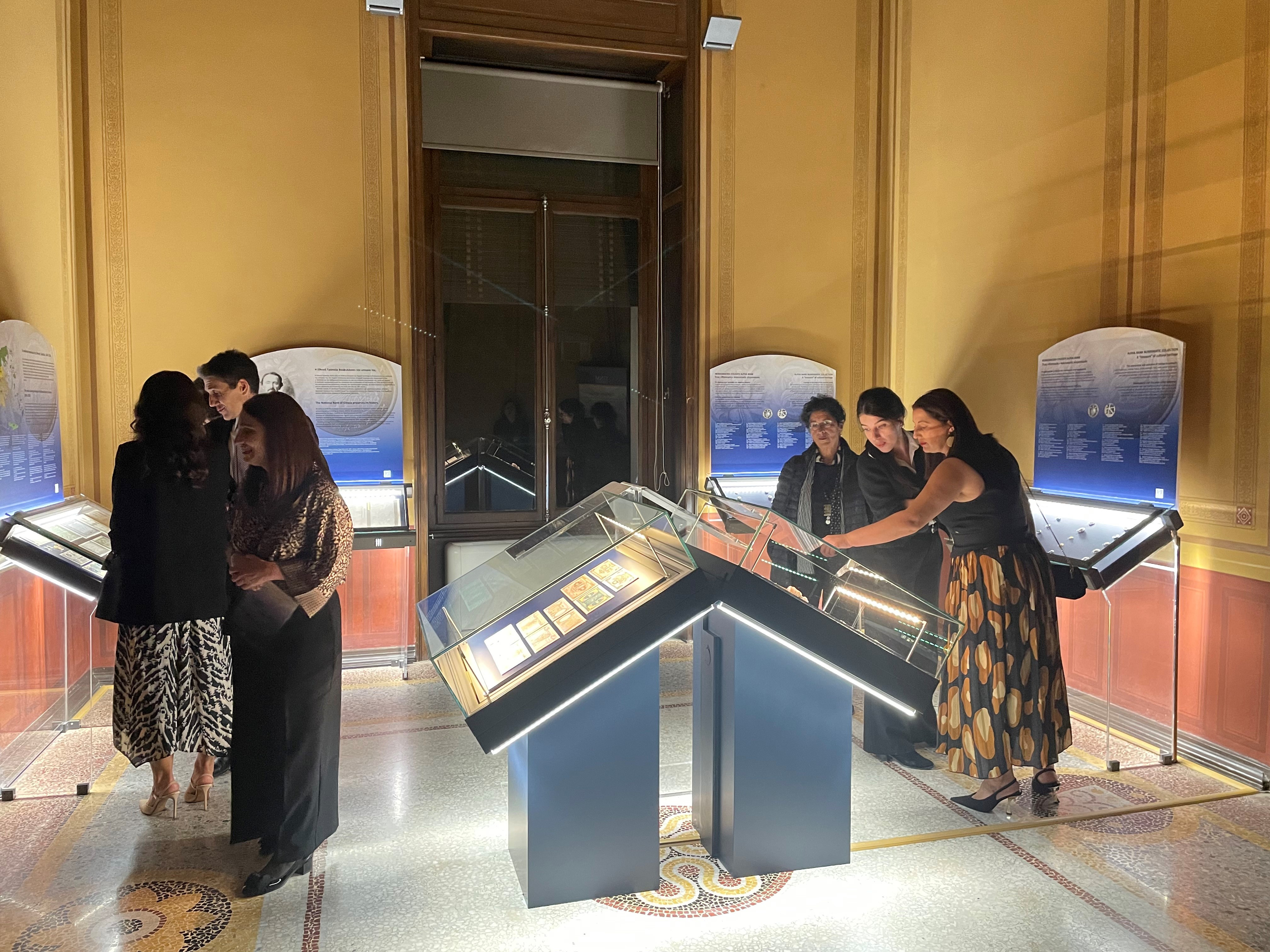 Visitors observing exhibits in the display cases. Highlight from the exhibition opening